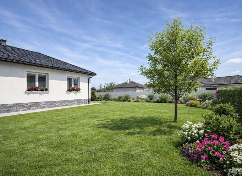 A family house in Zemianska Olča with a well-maintained garden and a flower bed.