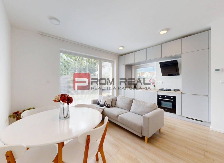 Living room with a kitchen and dining table in a three-room apartment, floor with wooden decor.