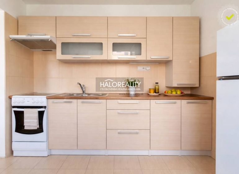 A kitchen in a studio apartment with wooden decor and a gas stove.