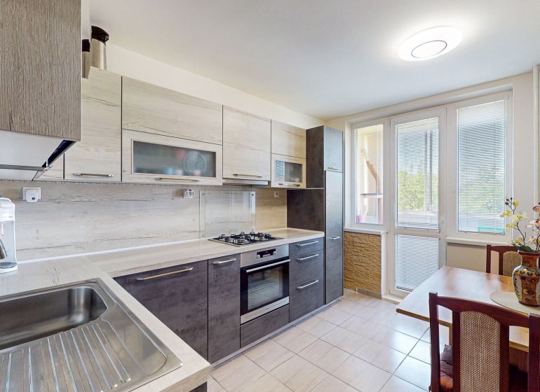 A kitchen in a 3-room apartment with a modern kitchen unit and a dining area.