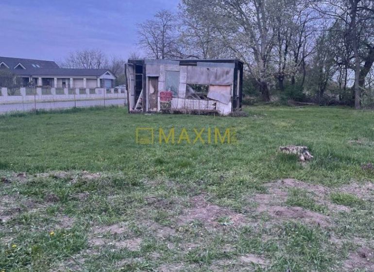 Plots - residential in the village of Slovenská Nová Ves with an old building and grassy vegetation.