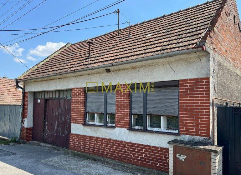 A family house in Dolné Orešany with a sloped roof and brick cladding on the facade.