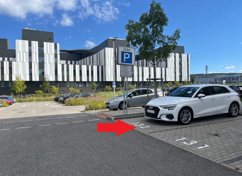 Parking lot with a parking zone sign and a modern building in Bratislava - Lamač.