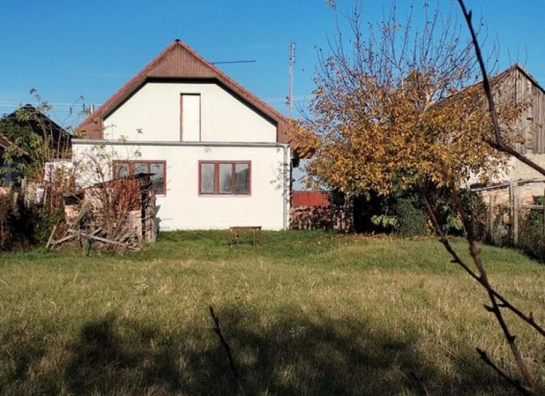 A family house in Veľké Úľany with a garden and greenery under a blue sky.