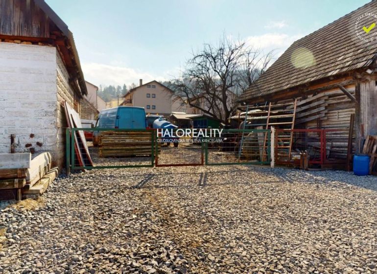 Stone courtyard with wooden buildings in the recreational grounds of Hybie.