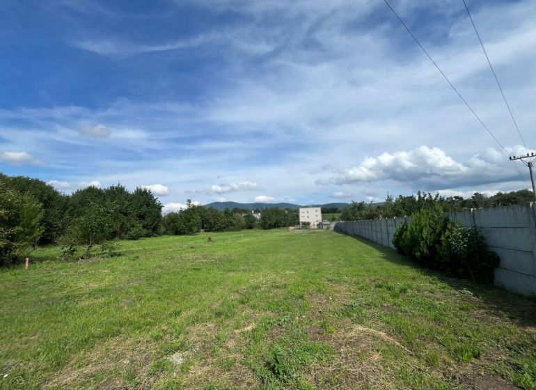 A plot on Ábovská Street in Ždaňa suitable for living, bordered by trees and a fence.