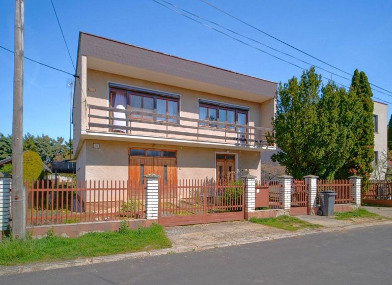 A family house in Veľký Lapáš with a garden and a wooden fence.