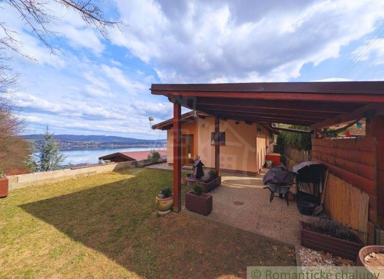 A cottage in Kvakovce with a view of the water surface and a garden terrace.
