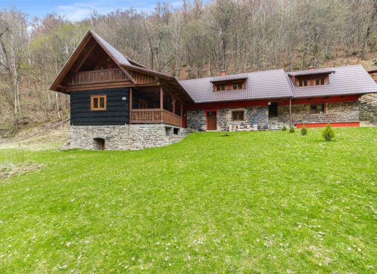 A family house in Horná Mariková with a roof and wooden elements, surrounded by forest.