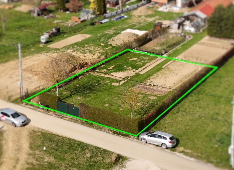 A residential plot in Kľače, bordered by a hedge, with an access road.