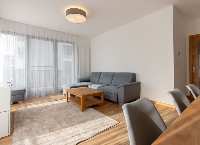 Living room in a 3-room apartment with a corner sofa and a wooden decor floor.