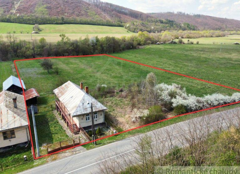 A family house in Zubné with a spacious plot, bordered by a road and trees.
