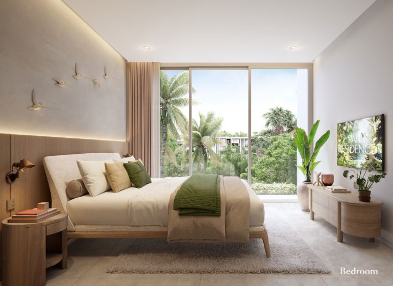 A bright bedroom with large windows, a bed, and wall decorations in a 2-room apartment.