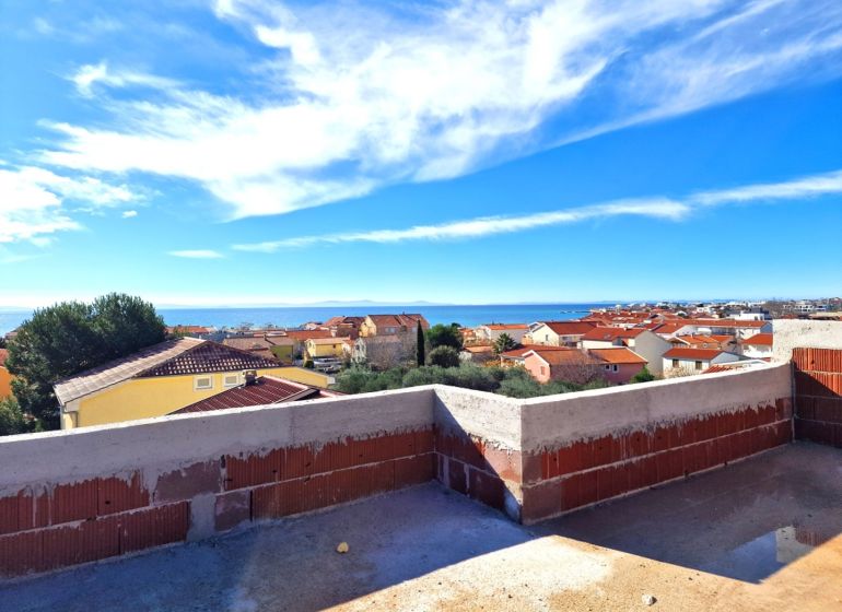 View from the terrace of a 3-room apartment in Privlaka to the sea and rooftops of houses.