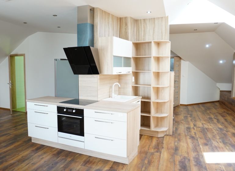 A kitchen in a 4-room apartment with built-in appliances and a wooden decor floor.