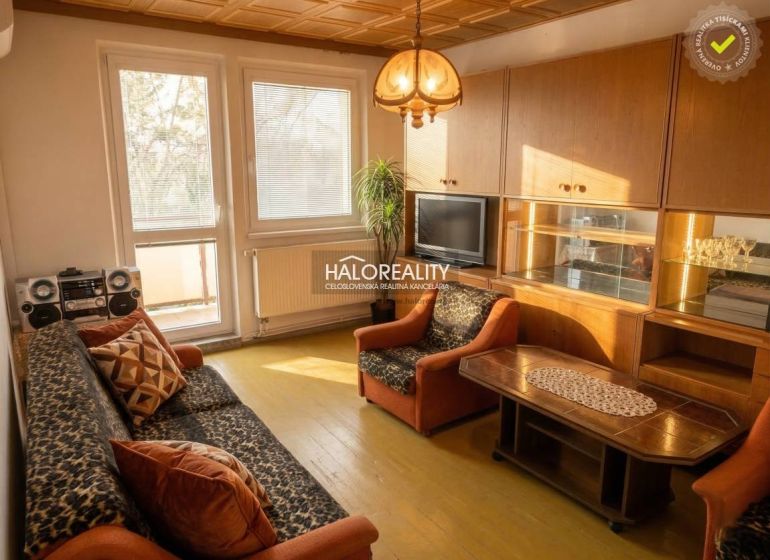 Living room in a 3-room apartment with a wooden decor floor and retro furniture.