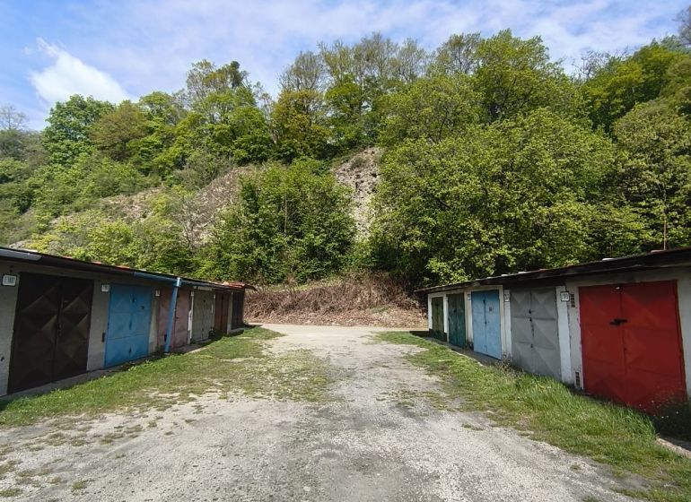 Parking garages on Dlhá Street in Prievidza surrounded by natural forests and the sky.