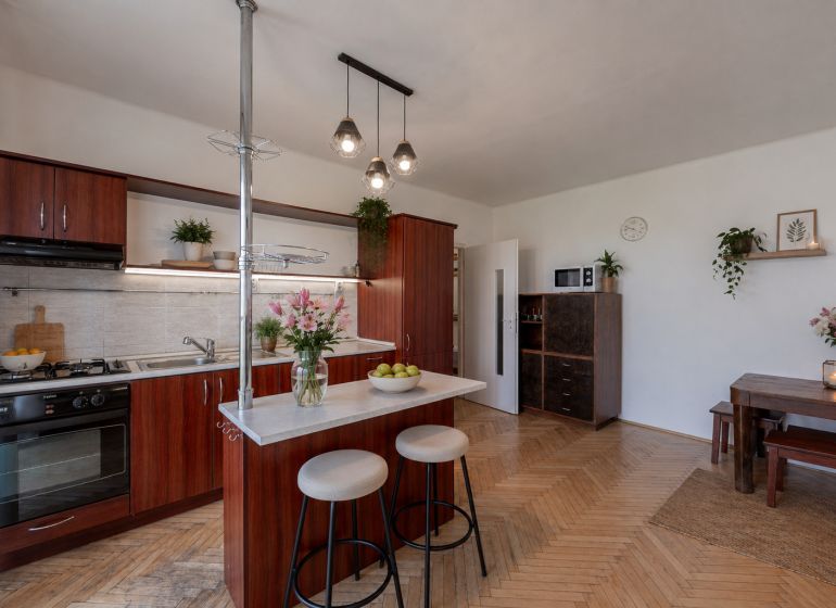 A kitchen in a 2-room apartment with a wooden decor countertop and floor.