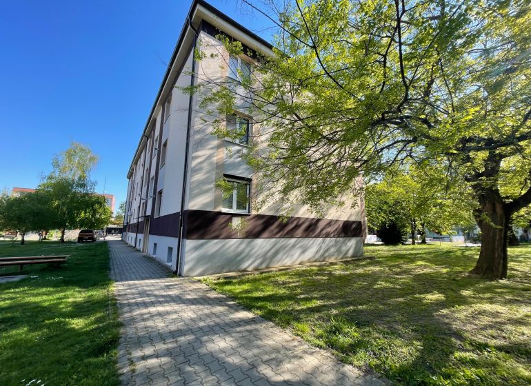 The exterior of the apartment building on Zornička Street in Galanta, surrounding greenery and sidewalk.