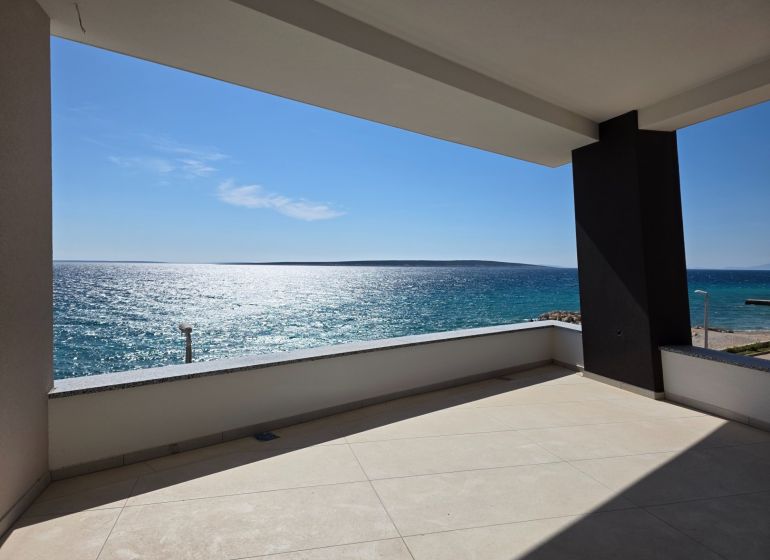 A terrace with a sea view in a 3-room apartment in Mandre, sunny weather, clear sky.