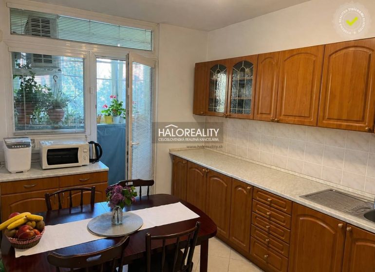A kitchen in a 3-room apartment with wooden cabinets and access to a balcony.