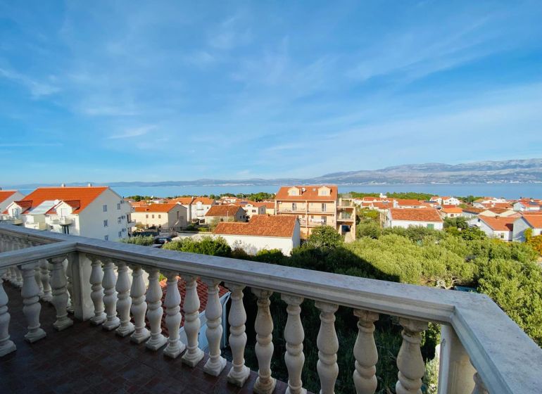 View from the terrace of a holiday apartment in Brač to the sea and rooftops of houses.