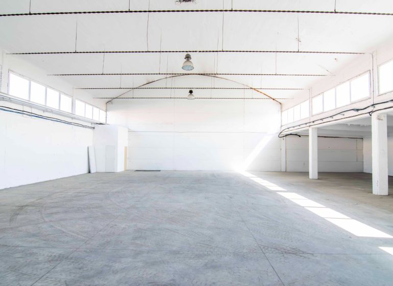 Spacious interior designed for warehouses and halls with a concrete floor and white walls.