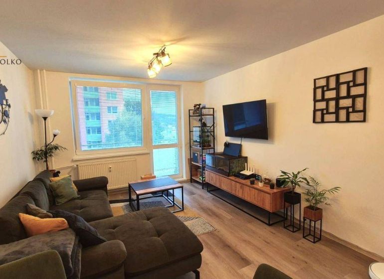 Living room in light tones, floor with wood decor, comfortable sofa, 3-room apartment.