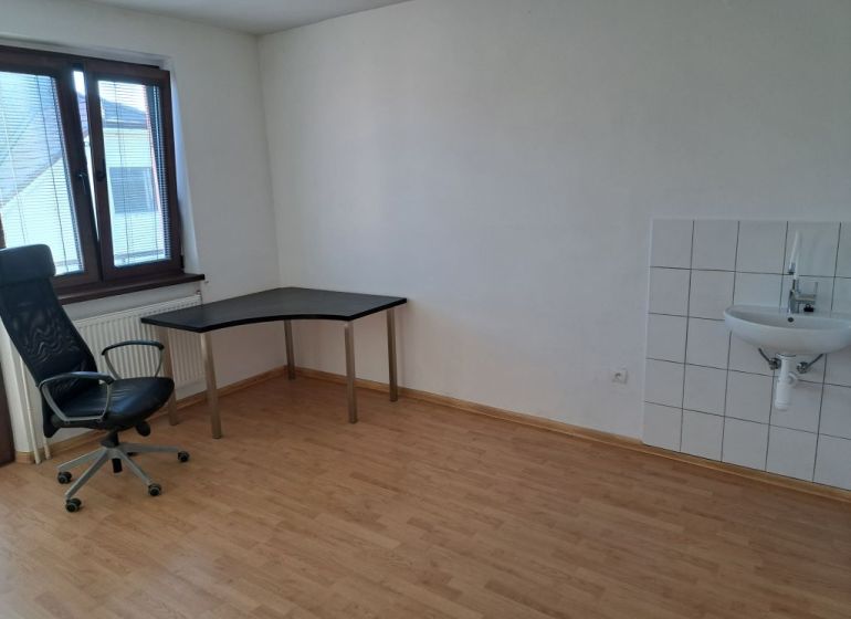 Offices with wood-patterned flooring, a desk, and a chair.