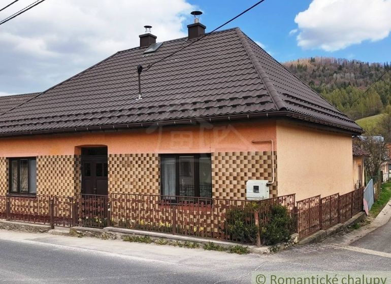 A family house in Reľov with a brown roof and an interesting facade by the road.