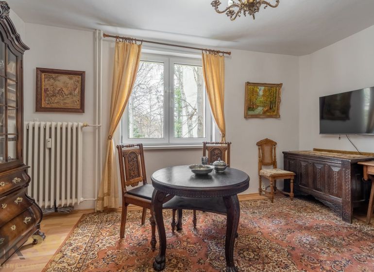 Interior of a 4-room apartment with wooden decor, antique furniture, and decorative carpets.
