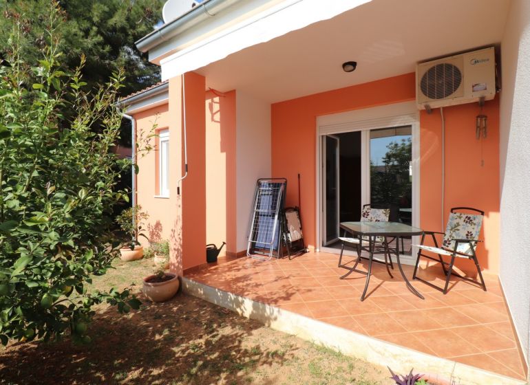 A family house in Vodice with a terrace, garden, and orange facade.