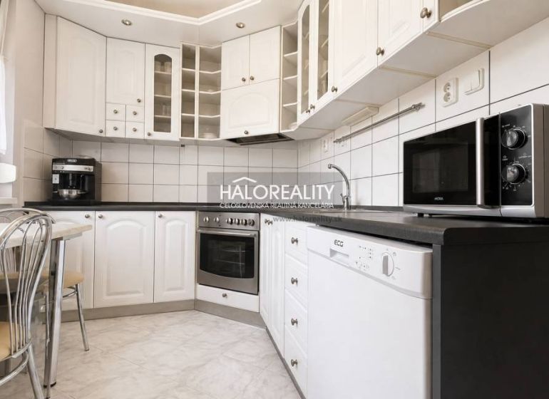 A kitchen in a 3-room apartment with a white kitchen unit and appliances.