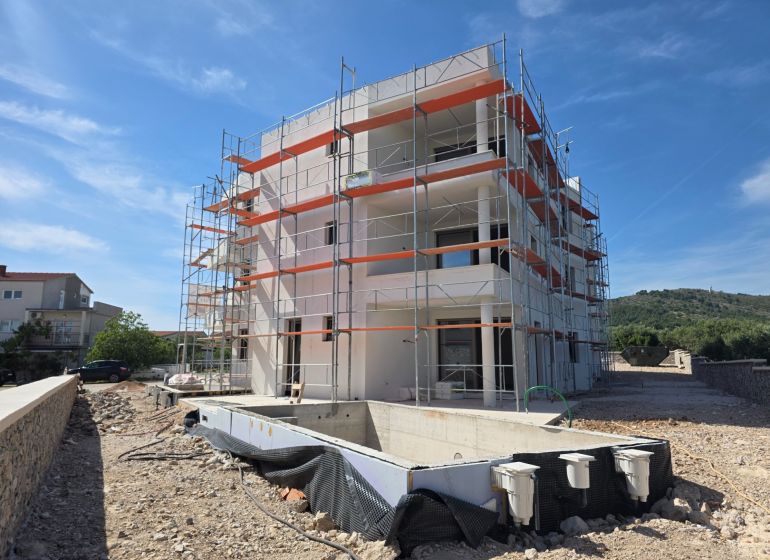 Construction of a 3-room apartment in Tribunj with an in-ground pool and scaffolding.