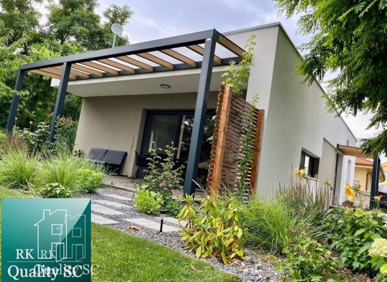 A family house in Senec with a garden and a covered terrace surrounded by greenery.