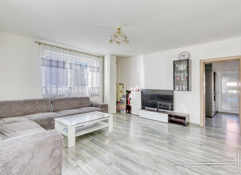Living room in a family house with a corner sofa and a wooden decor floor.