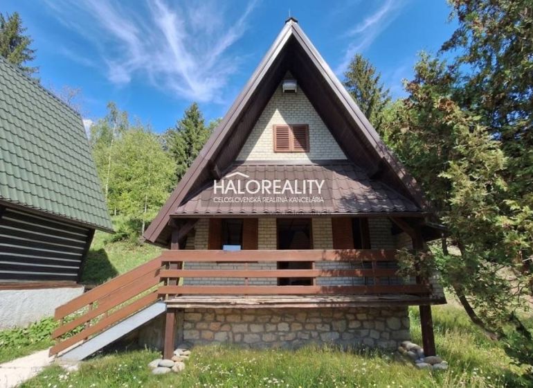 A cottage in Chyžné surrounded by forest and blue sky, suitable for relaxation.