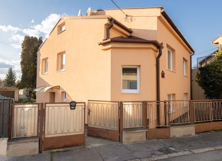 A family house on Mlynska Street in Piešťany with an orange facade and a fence.