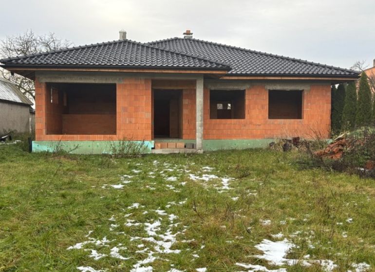 Unfinished family house in Dúbravka, with a black roof and empty windows, in a winter garden.