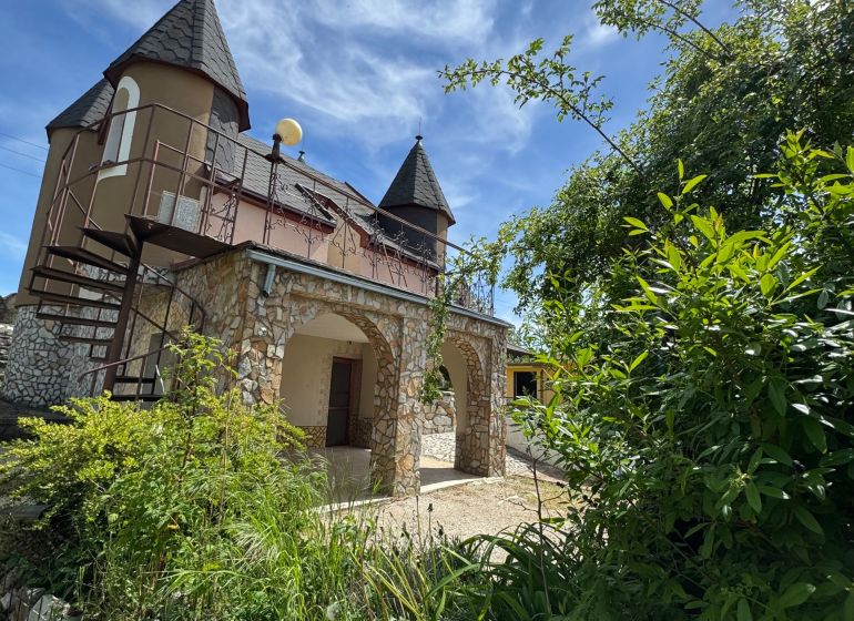 A cottage on Agátová Street in Šahy with stone arches and turrets.