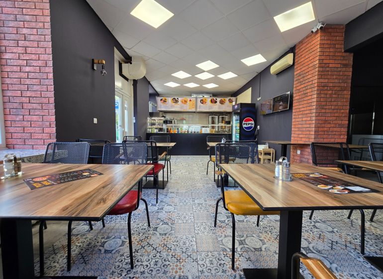 Gastro premises with a wooden decor floor and brick wall cladding.