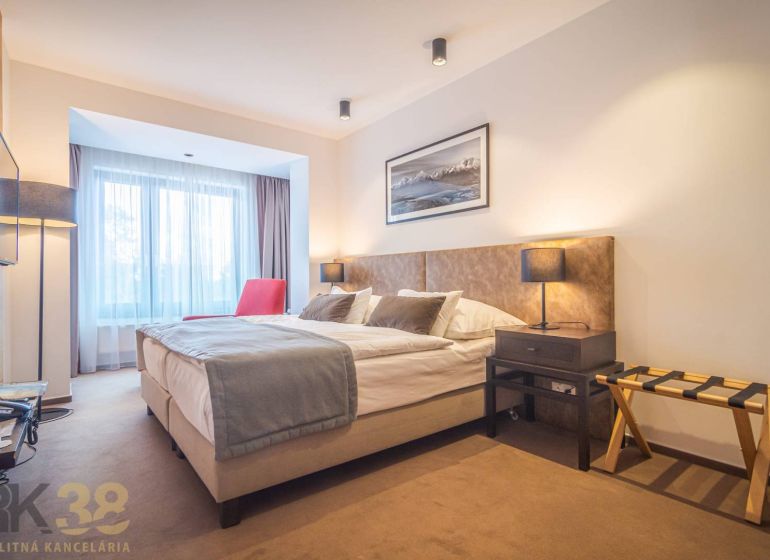 Recreational apartment with a comfortable bed, red armchair, and soft lighting.
