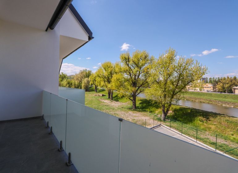 A balcony with a view of the river and greenery near Moravanská Street in Banka.