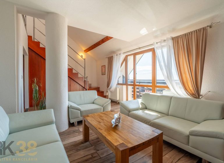 Living room with a light sofa, stairs, and a floor with a wood decor in a 4-room apartment.