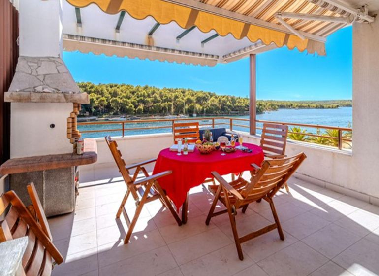 Terrace of a recreational apartment in Brač with a sea view and outdoor seating.