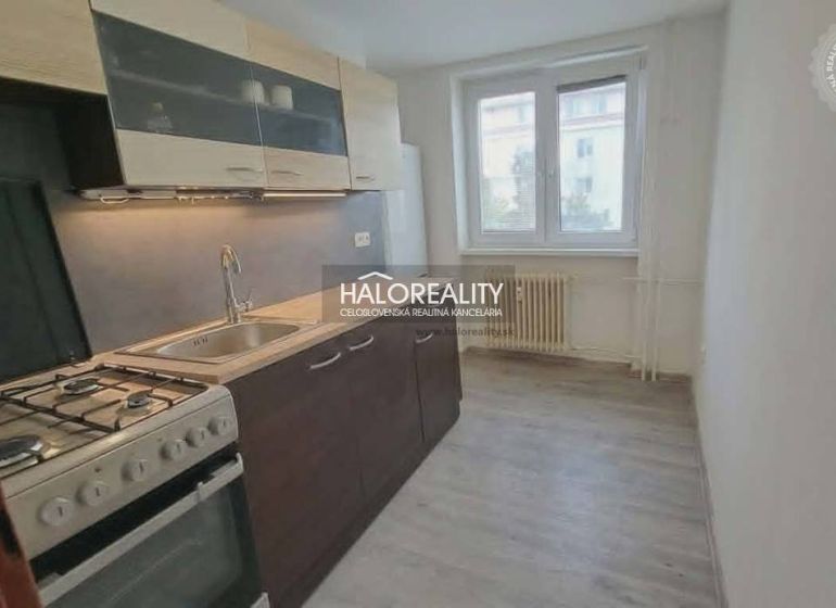 A kitchen in a 3-room apartment with a gas stove and a floor with a wood decor.