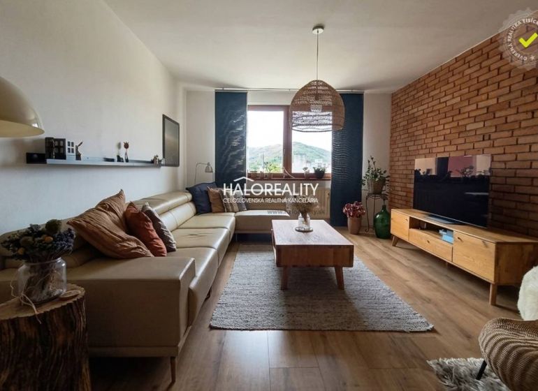 Living room with a leather sofa, TV, and wooden decor flooring in a 3-room apartment.