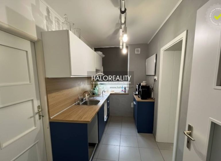 A kitchen in a family house with a wooden decor countertop and light cabinets.