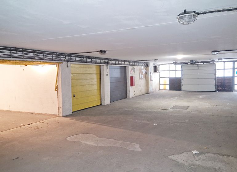 The interior of a garage with multiple doors, a well-lit and spacious area.