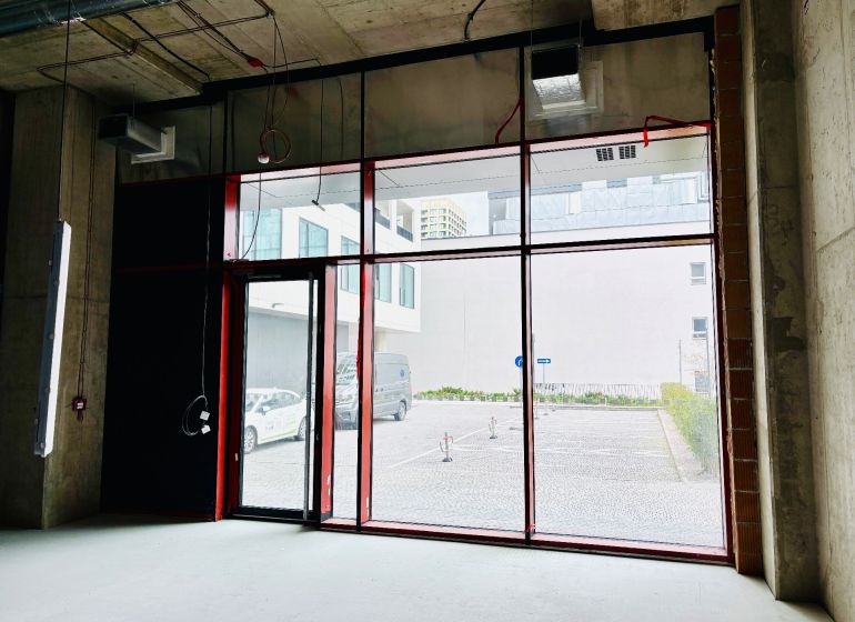 Commercial spaces with large glass doors and raw concrete walls.